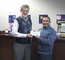 Photograph of Mario Ramirez handing check to David Bugli